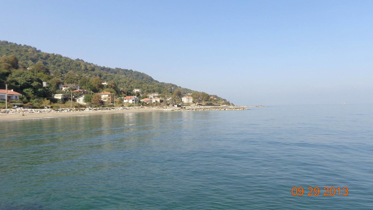 water, clear sky, copy space, sea, waterfront, mountain, blue, tranquil scene, building exterior, scenics, tranquility, beauty in nature, nature, built structure, house, architecture, nautical vessel, tree, town, idyllic