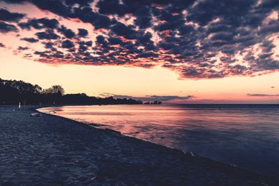 Scenic view of sea against dramatic sky during sunset