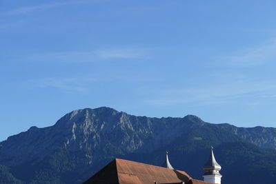 High section of building and mountains against blue sky