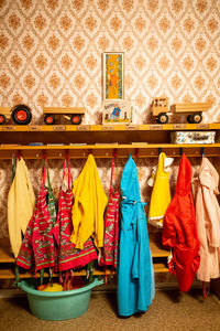 Multi colored clothes hanging on floor against wall