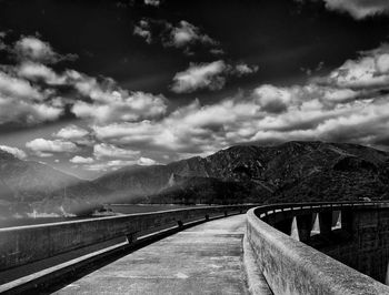 Footbridge over river against mountains