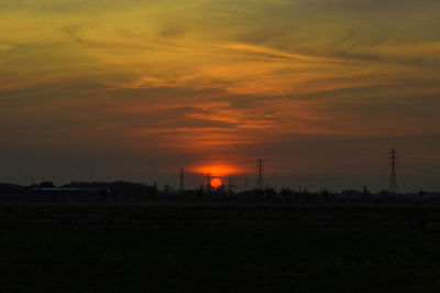Scenic view of silhouette field against sky during sunset