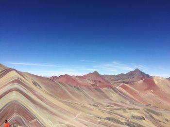 Scenic view of mountain range against blue sky