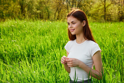 Portrait of young woman holding grass