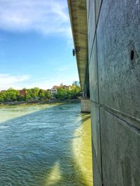 Scenic view of river by building against sky