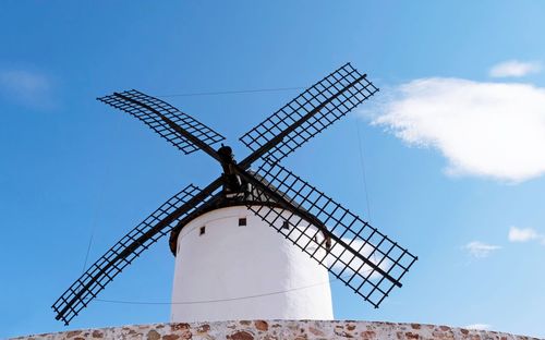 Low angle view of traditional windmill against sky