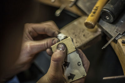 Midsection of person working on metal