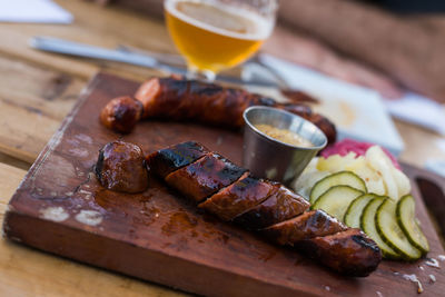 Close-up of sausages and salad on cutting board