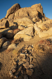 Rock formations in desert with stone covered grave with stone cross