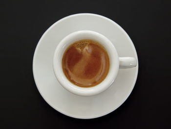 Directly above shot of coffee cup against black background