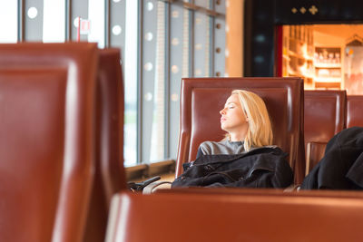 Woman looking away while sitting on seat