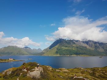 Scenic view of lake by mountains against sky