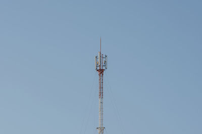 Low angle view of communications tower against clear blue sky