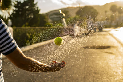 Midsection of man playing with ball in water