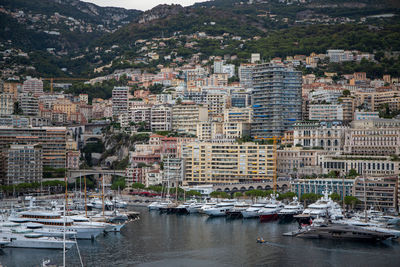 Boats moored in harbor by buildings in city