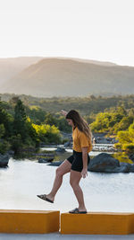 Woman standing on mountain against sky