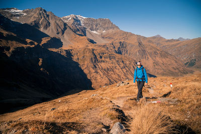 Full length of man hiking on mountain against sky