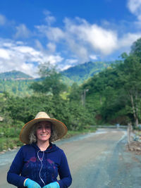 Portrait of a smiling young woman against trees