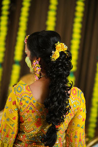 Rear view of woman standing against wall