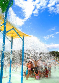 People playing on water against sky