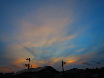 Low angle view of silhouette houses against sky during sunset