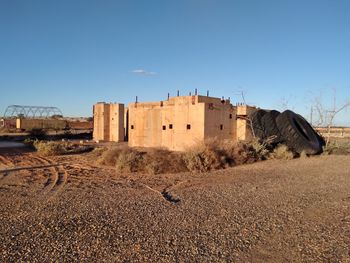 Buildings in desert against clear blue sky