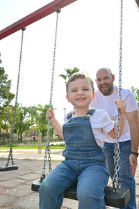 Portrait of boy swinging at playground