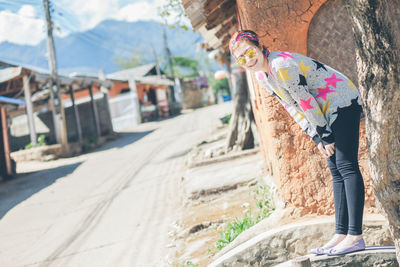 Portrait of woman standing against built structure in city