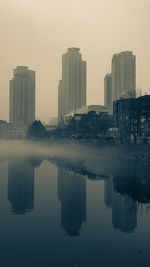 Reflection of buildings in lake against sky