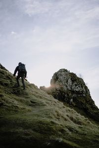 Rear view of man on rock against sky