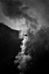 Low angle view of silhouette airplane flying in sky