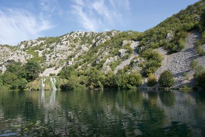 Scenic view of lake by trees against sky