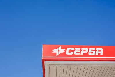 Low angle view of information sign against blue sky