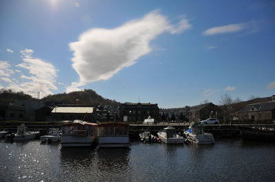 Boats moored in water against sky