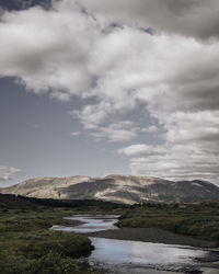 Scenic view of mountains against cloudy sky