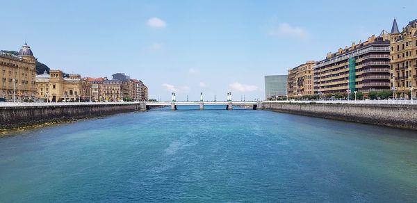 Buildings by swimming pool in city against sky