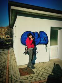 Full length of boy standing against wall