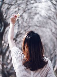 Rear view of woman with arms raised