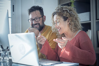 Man and woman using laptop at home