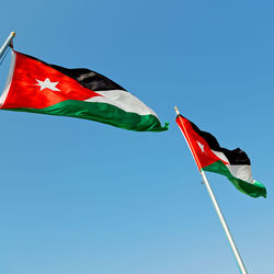 Low angle view of flag against blue sky