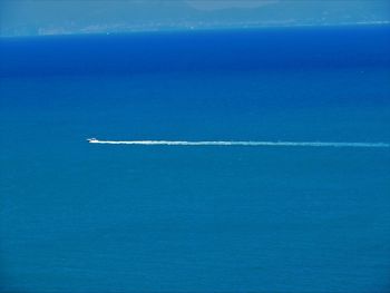 Aerial view of sea against blue sky