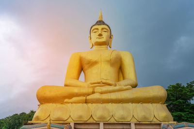 Low angle view of statue against temple against sky