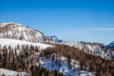 Scenic view of snowcapped mountains against blue sky