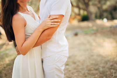 Midsection of couple standing against blurred background