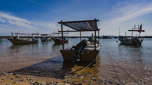 Boat moored on sea against sky