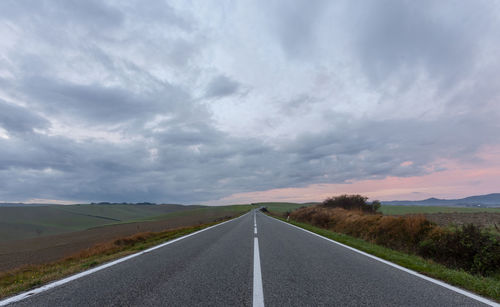 Empty road along countryside landscape