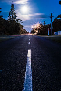 Road by trees against sky