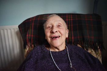 Portrait of happy senior woman resting on sofa at home