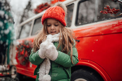 Portrait of smiling young woman standing in car