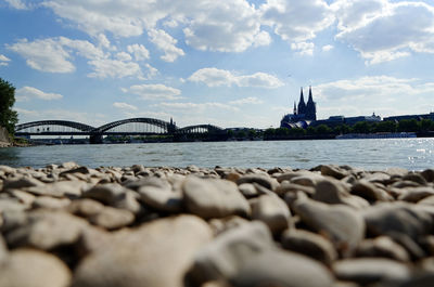 Bridge over river against cloudy sky